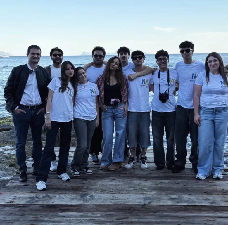 I volontari di Nuovo Agire con la maglietta dell'associazione, sul mare di Napoli